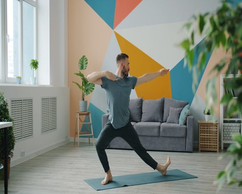 Man stretching arms gently in the living room